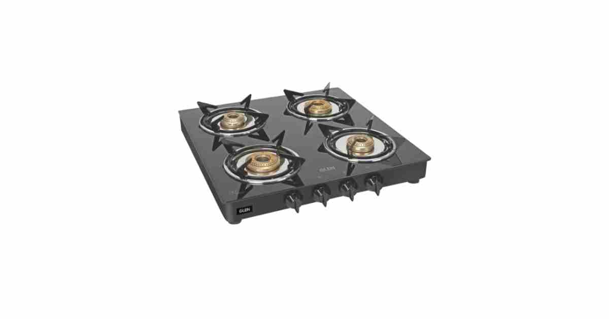 Modern modular kitchen with a sleek 4 burner gas chulha on countertop.
