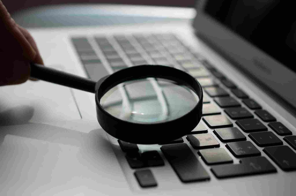 Magnifying glass on laptop keyboard representing search visibility